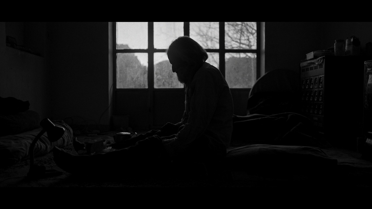 Silhouette of a man sitting on the floor